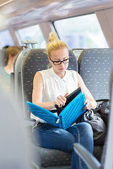 Image showing Woman travelling by train working on laptop.