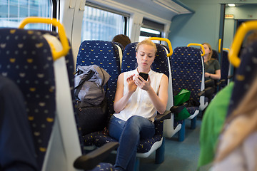 Image showing Woman using mobile phone while travelling by train.