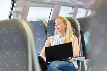 Image showing Woman sleeping while travelling by train.