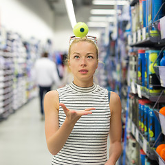 Image showing Woman shopping tennis balls in sportswear store.