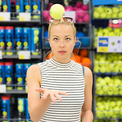 Image showing Woman shopping tennis balls in sportswear store.