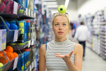 Image showing Woman shopping tennis balls in sportswear store.