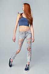 Image showing Modern red haired female wearing distressed jeans