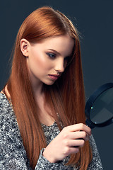 Image showing Woman looking through magnifying glass