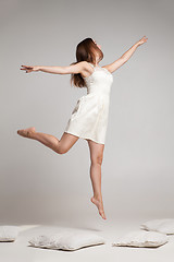 Image showing Flying brunette in white dress