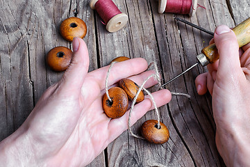 Image showing Stringing beads on a string