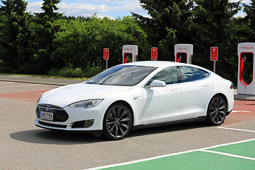 Image showing White Tesla Model S Electric Car Leaves Charging Station 