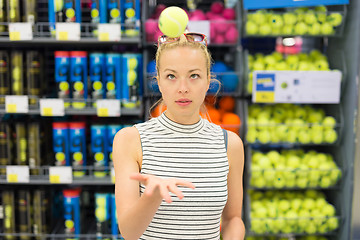 Image showing Woman shopping tennis balls in sportswear store.