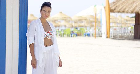 Image showing Cheerful pretty woman in white robe on beach