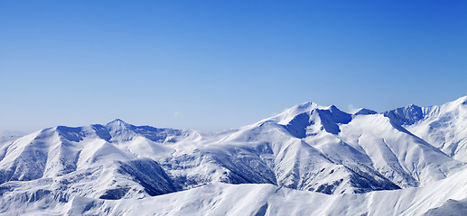 Image showing Panoramic view on snowy winter mountains and blue sky