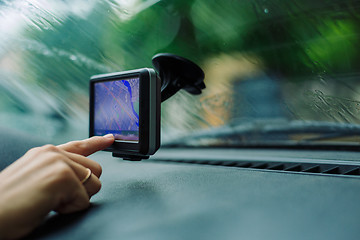 Image showing woman looks at a GPS Navigator in the car