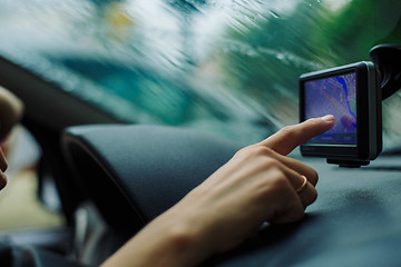 Image showing woman looks at a GPS Navigator in the car