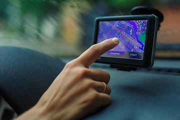 Image showing woman looks at a GPS Navigator in the car