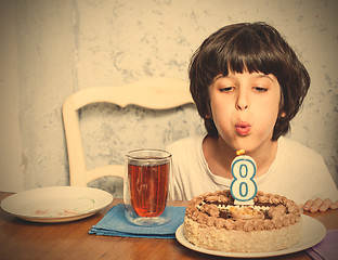 Image showing boy blowing out candles on birthday cake