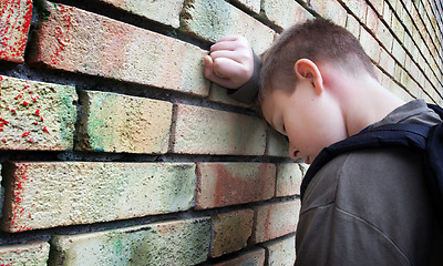 Image showing upset boy against a wall