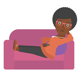 Image showing Woman sitting on the couch with remote control.