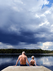 Image showing Grandfather and Grandson sitting on a footbridge