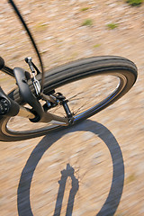 Image showing Front wheel of a bike on a dirt road