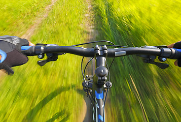 Image showing Fast motion mountain bike on a grassy road