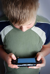 Image showing Boys hand playing portable video game