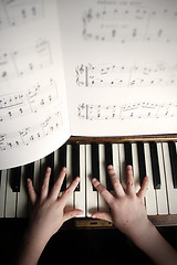 Image showing child's hands playing on a old piano