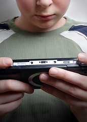 Image showing Boys hand playing portable video game