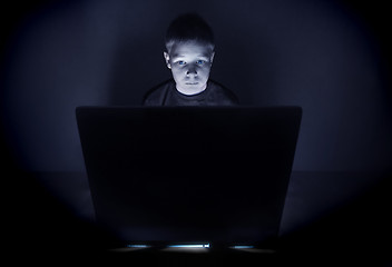 Image showing Boy illuminated by the blue light of a computer monitor
