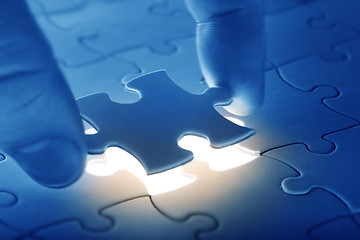 Image showing Hands placing last piece of a Puzzle