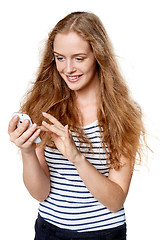 Image showing Woman texting on her cell phone