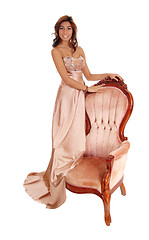 Image showing Young woman standing on armchair.