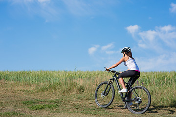 Image showing Sport bike woman on the meadow with a beautiful landscape