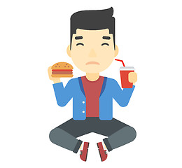 Image showing Man eating hamburger. 