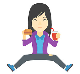 Image showing Woman eating hamburger. 