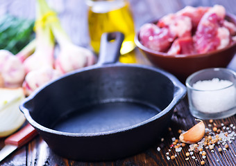 Image showing raw meat and pan on a table