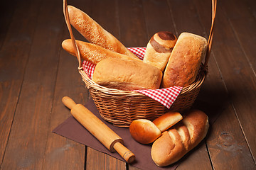 Image showing Arrangement of bread in basket and rolling pin 