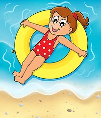 Image showing Girl on swim ring at seashore