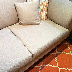Image showing Gray sofa with cushions on orange carpet