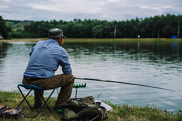 Image showing Man catches fish with a fishing rod