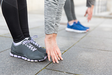 Image showing close up of couple stretching on city street