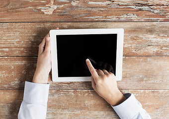 Image showing close up of female hands with tablet pc on table