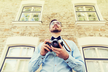 Image showing happy young hipster man with film camera in city