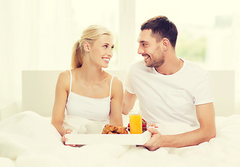 Image showing happy couple having breakfast in bed at home