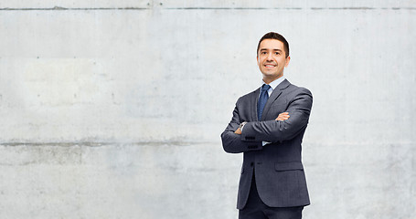 Image showing happy smiling businessman over gray concrete wall 