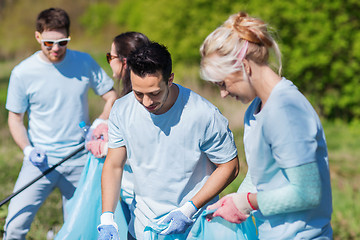 Image showing volunteers with garbage bags cleaning park area