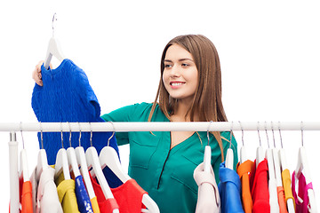 Image showing happy woman choosing clothes at home wardrobe