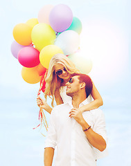 Image showing couple in sunglases with colorful balloons