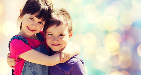 Image showing two happy kids hugging over blue lights background