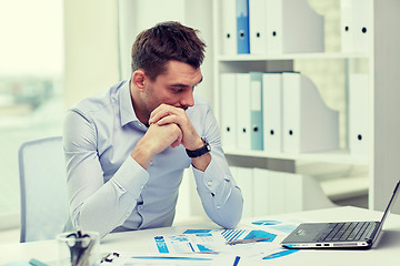 Image showing stressed businessman with laptop and papers