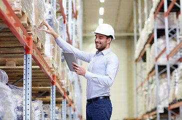 Image showing happy businessman with tablet pc at warehouse