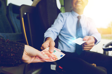 Image showing close up of bus driver selling ticket to passenger